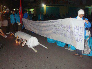 keranda mayat peserta refleksi mengangkat spanduk yang berisi tuntutan mereka dan di depan spanduk tersebut terdapat keranda yang melambangkan kematian idealisme mahasiswa