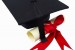 Close up of a graduation cap and a certificate with a ribbon